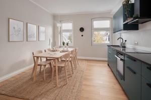 Jugendstil-Altbauwohnung an der Karlsaue - 120qm, Klimaanlage, neu saniert, zentrale Lage في كاسيل: مطبخ مع طاولة وكراسي في الغرفة