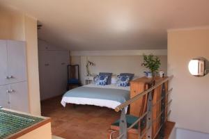 ein Schlafzimmer mit einem Bett mit blauen Kissen darauf in der Unterkunft Casa Azahar in Saleres