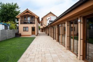 a row of houses with a walkway at Scarlett Pension & Restaurant in Veľký Meder