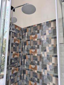 a bathroom with a shower with a mosaic tile wall at La Rosa dei Venti in Savona +47 photos