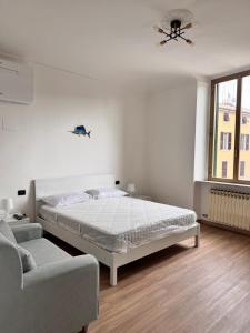 a white bedroom with a bed and a couch at La Rosa dei Venti in Savona