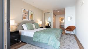 カマラ・デ・ロボスにあるOceanfront Elegance Madeira Retreatのベッドルーム1室(大型ベッド1台、緑の毛布付)