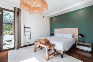 a bedroom with a bed and a green wall at Luxury Boutique B&B - Villa Prana Marbella in Ojén