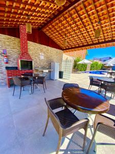 a patio with tables and chairs and a fireplace at Flat premium centro de Porto de Galinhas-Makambira Residence-Flat309 in Porto De Galinhas +64 photos