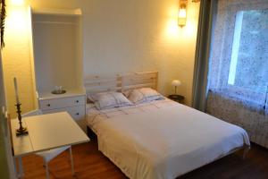 a bedroom with a bed and a table and a window at Pan Tadeusz pokoje gościnne in Siemiatycze