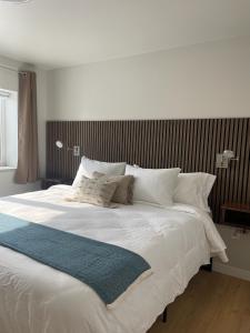 a large bed with white sheets and pillows at DWELL in Alaska Apartment d in Fairbanks