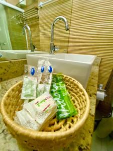 a basket of toiletries in a bathroom with a sink at Flat premium centro de Porto de Galinhas-Makambira Residence-Flat309 in Porto De Galinhas