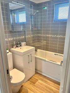 a bathroom with a toilet and a sink and a tub at Oakwood Lodge in Cheswick