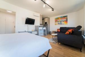 a living room with a black couch and a tv at Apartman EpiCent in Tuzla