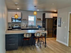 cocina con encimera y 3 sillas en una isla de cocina en DWELL in Alaska Apartment e, en Fairbanks