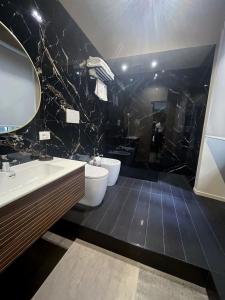 a bathroom with two sinks and two toilets at PRIMO RE, Luxury Rooms in Campobasso