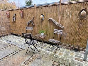 a patio with two chairs and a table and a fence at Apartment am Minoritenhof in Sinzing