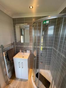 a bathroom with a shower and a sink at Oakwood Lodge in Cheswick +16 photos