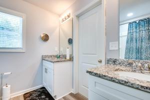 a white bathroom with a sink and a mirror at Atlanta Home with Patio, 8 Mi to Downtown and Aquarium in Atlanta +18 photos