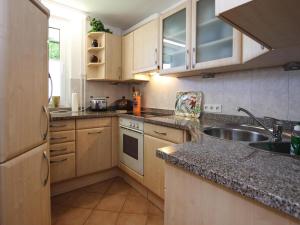a kitchen with wooden cabinets and a sink at Ferienwohnung Zauberhexe in Braunlage in Braunlage