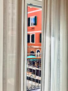 a view of a building through a window with curtains at La Ripa Camere Vernazza - La Medusa Studio in Vernazza