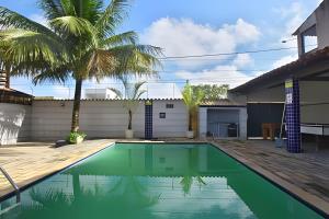a swimming pool in the backyard of a house with a palm tree at Casa em Iguaba Grande - RJ (Região dos Lagos) (1) in Iguaba Grande +119 photos