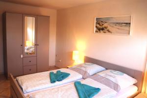 ein Schlafzimmer mit zwei Betten mit blauen Handtüchern darauf in der Unterkunft Ferienwohnung Borkum in Holtgast