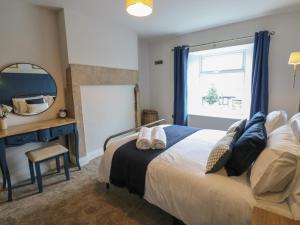 a bedroom with a bed and a desk and a mirror at Hollywood Cottage in Barnard Castle