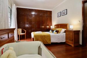 a bedroom with a bed and a dresser and a chair at Villa Rose by AnaLodges in São Vicente +24 photos