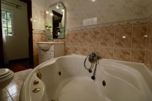 a white bath tub in a bathroom with a toilet at Villa Rose by AnaLodges in São Vicente