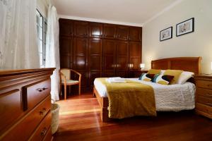 a bedroom with a bed with a wooden headboard at Villa Rose by AnaLodges in São Vicente