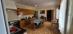 a kitchen with wooden cabinets and a table with chairs at Santa Barbara Beach hotspot in Ribeira Grande