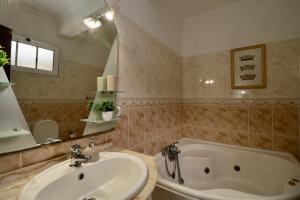 a bathroom with a sink and a bath tub at Villa Rose by AnaLodges in São Vicente