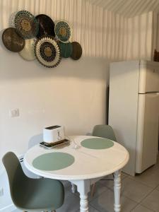 a kitchen with a table and chairs and a refrigerator at Appartement cosy centre du Crès in Le Crès +9 photos