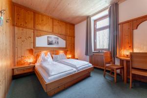 sypialnia z łóżkiem i biurkiem w obiekcie Hotel Gasthof Post w mieście Bruck an der Großglocknerstraße