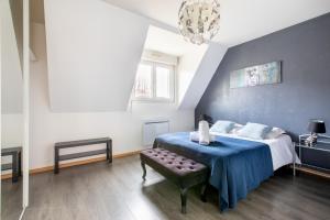 sypialnia z łóżkiem z niebieskim kocem w obiekcie Choupette de la vallée avec garage w mieście Kaysersberg