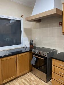a kitchen with a stove and a large window at Santa Barbara Beach hotspot in Ribeira Grande +20 photos