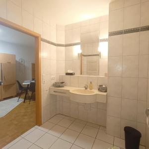 Un baño blanco con lavabo y espejo. en TauberNest, en Bad Mergentheim