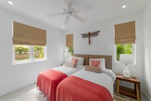 two beds in a bedroom with white walls and windows at 17 Westmoreland Hills in Saint James +18 photos