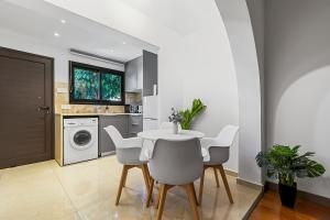 a dining room with a table and chairs in a kitchen at Orange Tree Studio, just steps from the sea in Paphos City +13 photos