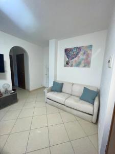 Una sala de estar con un sofá y un cuadro en la pared. en Sunset Escape, relax a due passi dal mare con terrazza e aria condizionata, en Montesilvano