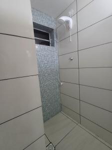 a bathroom with a shower with a glass door at Suite Térrea in Bombinhas +17 photos