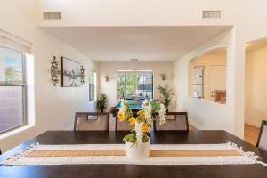 Una sala de estar con una mesa con flores. en Luxurious Retreat - FREE HTD Pool - Outdoor Fun, en Casa Grande