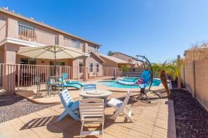 Un patio con mesa y sillas y una piscina. en Luxurious Retreat - FREE HTD Pool - Outdoor Fun, en Casa Grande