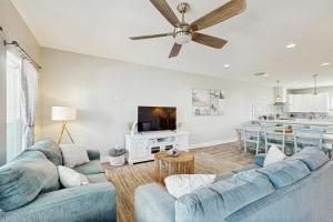 un soggiorno con divani blu e una cucina di Shoreline Retreat a Port Aransas