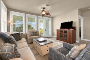 a living room with couches and a flat screen tv at Mannanan Mac Lir in Galveston