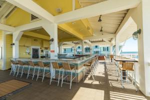 an outdoor patio with a bar with chairs and tables at Mannanan Mac Lir in Galveston