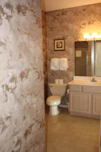 a bathroom with a toilet and a sink and a tub at 2 Bed Lakefront Condo at The Lake of the Ozarks in Lake Ozark +4 photos