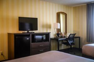 a hotel room with a television and a desk with a chair at Quality Inn Airport in Colorado Springs