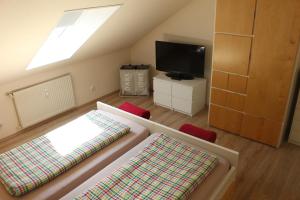 a attic room with two beds and a tv at Haus Homann-Schneider, Apartment Stefan in Wetter