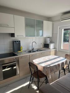 a kitchen with a table and a sink at Lavanda Apartments in Pakoštane