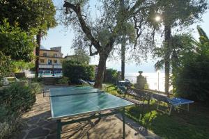 eine Tischtennisplatte in einem Park in der Nähe des Wassers in der Unterkunft Hotel Palazzina in Gargnano