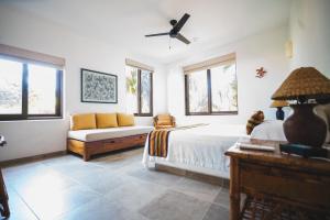 ein Schlafzimmer mit einem Bett und einer Couch und Fenstern in der Unterkunft Escondite condominios in Zihuatanejo + 20 Fotos