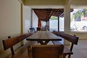 ein langer Holztisch mit zwei Stühlen in einem Raum in der Unterkunft Linda casa em Porto da Aldeia (Cabo Frio) - RJ in São Pedro da Aldeia
