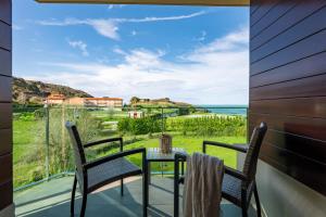 a table and chairs on a balcony with a view of the ocean at Miracielos in Barro de Llanes